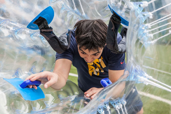 Player climbing inside a bubble to play bubble football